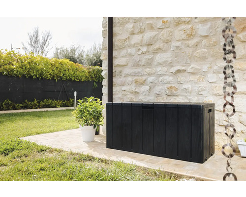 Gartenszene mit einer schwarzen Gartenbox zur Aufbewahrung im Aussenbereich