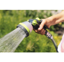 Main tenant une tête de pulvérisation de tuyau d'arrosage avec un jet d'eau