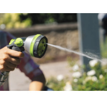 Une main tient un pistolet d'arrosage d'où jaillit de l'eau.