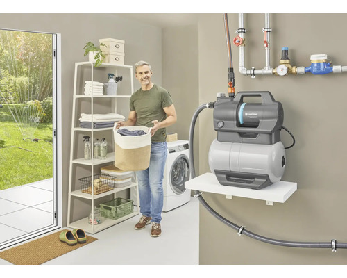 Hauswasserautomat im Waschraum mit Regal und Mann, der Wäschekorb trägt