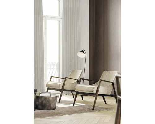 Deux fauteuils avec cadre en bois, lampadaire et rideaux dans un salon.