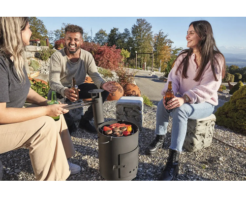 Gruppe von Freunden grillt im Freien mit einem Holzkohlegrill, während sie Getränke genießen.