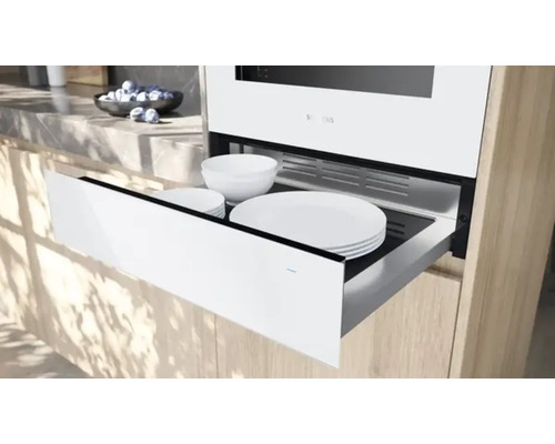 Scène de cuisine avec chauffe-assiettes et vaisselle