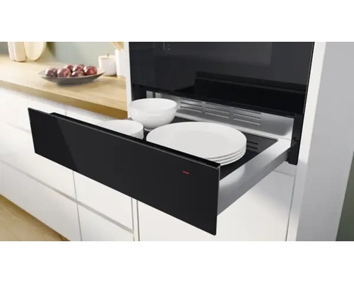 Tiroir chauffe-plat ouvert avec vaisselle dans une cuisine moderne