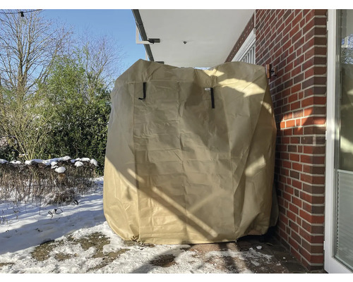 Barbecue couverte avec housse de protection sur une terrasse en hiver.