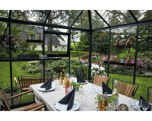 Gewächshaus mit Esstisch, Stühlen und Gartenaussicht