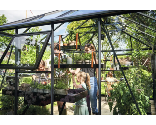 Familie im Gewächshaus mit Pflanzen und Regalen