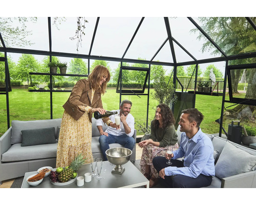 Scène dans une serre avec un groupe de personnes assises à une table et dégustant des boissons
