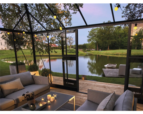 Vue intérieure d''une serre avec des sièges et vue sur un lac