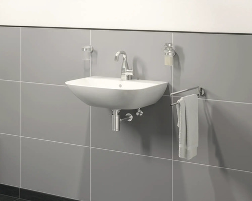 Lavabo avec robinet, porte-serviettes, distributeur de savon et gobelet à brosse à dents sur un mur gris