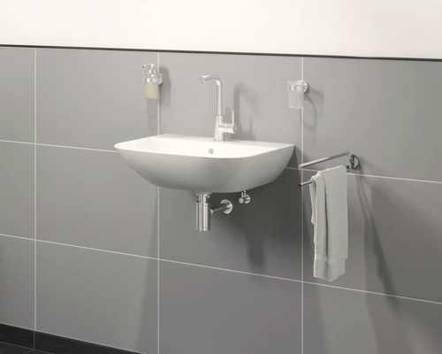 Lavabo suspendu avec robinet, distributeur de savon, gobelet à brosse à dents et porte-serviettes devant un mur gris