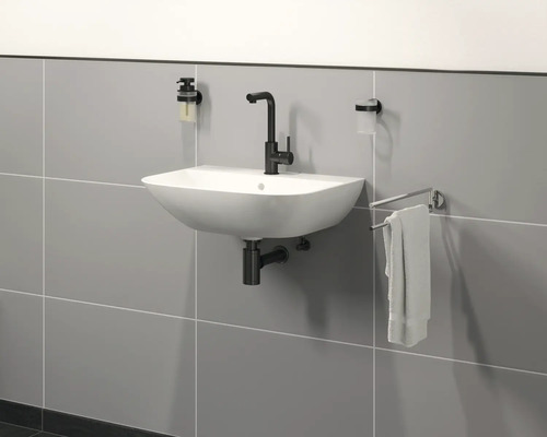 Salle de bains moderne avec lavabo, robinet, distributeur de savon, gobelet à brosse à dents et porte-serviettes