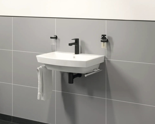 Lavabo de salle de bains moderne avec robinet, serviette et distributeur de savon sur mur carrelé gris