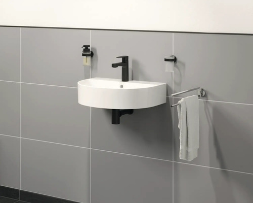 Salle de bains moderne avec lavabo à poser, robinetterie, distributeur de savon et porte-serviettes mural.