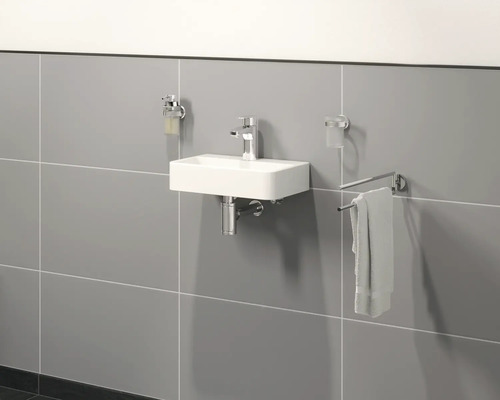 Badezimmer mit Waschbecken, Armatur, Seifenspender, Handtuchhalter und Fliesen