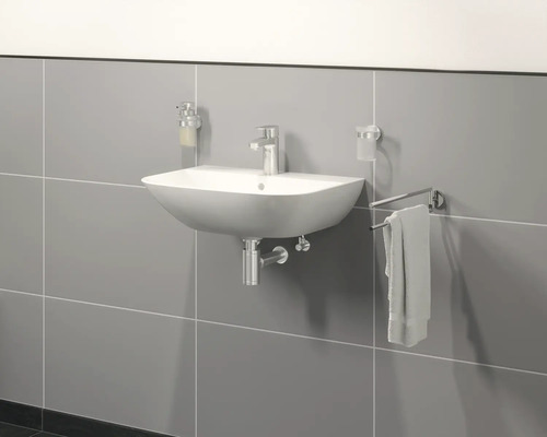 Lavabo mural avec robinet, distributeur de savon, gobelet à brosse à dents et porte-serviettes sur un mur gris