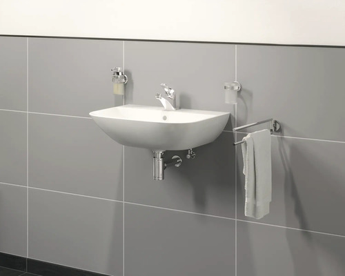 Lavabo avec robinet, distributeur de savon et porte-serviettes sur un mur carrelé