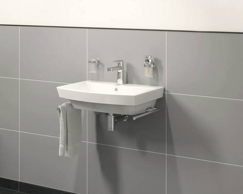 Hängewaschtisch mit Armatur und Zubehör an grauer Wand