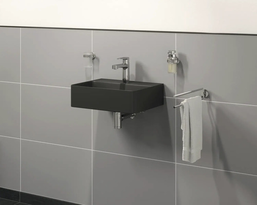 Salle de bains moderne avec lavabo noir, robinet, distributeur de savon et porte-serviettes mural.