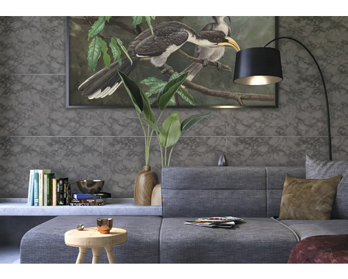 Salon avec canapé gris, bibliothèque, lampadaire et peinture murale