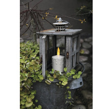 Dekorative Szene mit einer Laterne, einer LED-Kerze und einer Pflanze in einem Eimer.