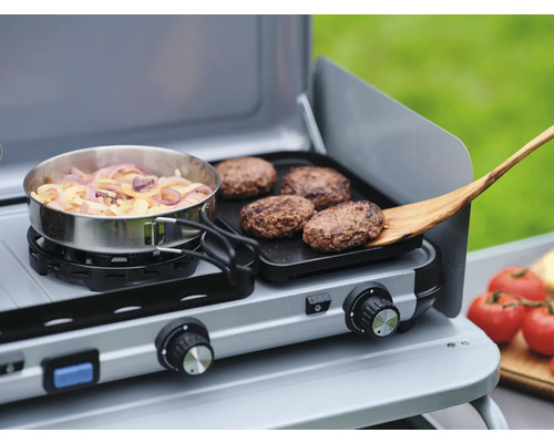 Zweiflammenkocher mit Pfanne, Zwiebeln, Bratlingen und Holzspatel