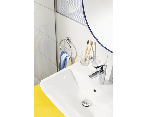 Vue détaillée d''un lavabo avec robinet, porte-serviettes, gobelet pour brosses à dents et miroir dans une salle de bains