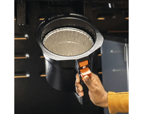 Une main tient un seau de récupération des graisses pour barbecue, doublé d''une feuille d''aluminium.