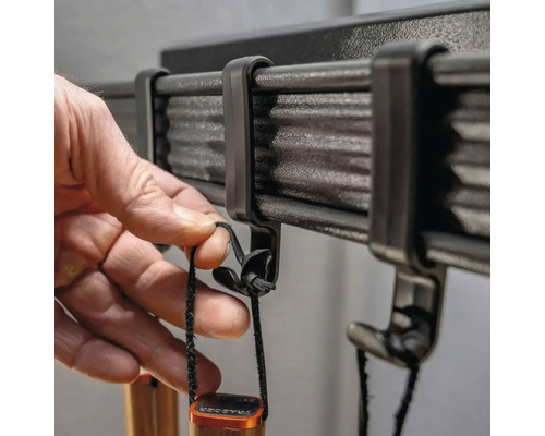 Werkzeughalter mit Hand beim Einhängen eines Werkzeugs