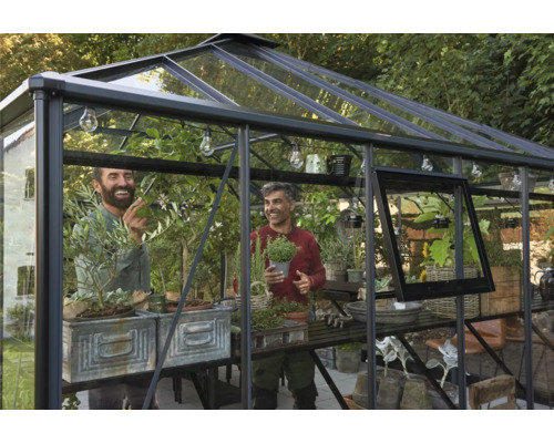 Gewächshaus mit zwei Männern, Pflanzen und Tischen