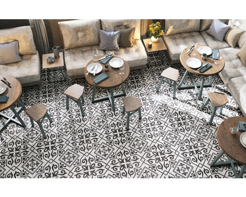 Innenraum mit Bodenfliesen im Retro-Stil, Tischen und Sitzgelegenheiten.