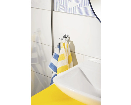 Salle de bains lumineuse avec lavabo, porte-serviettes et serviettes rayées