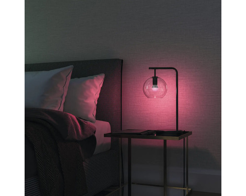 Chambre à coucher avec lit, table de chevet et lampe de table avec globe en verre