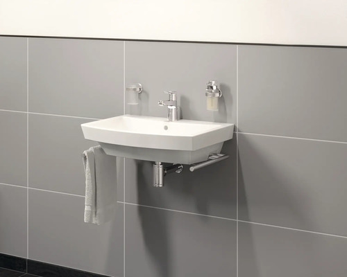 Keramik Waschbecken mit Armatur und Handtuchhalter an gefliester Wand