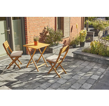 Scène de jardin avec table en bois et deux chaises sur pavés devant une maison