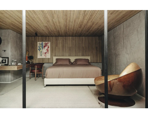 Schlafzimmer mit Bett, Schreibtisch, Stuhl und Kunstwerk