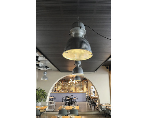Innenraum eines Restaurants mit Tischen, Stühlen und Hängelampen im Industriedesign.