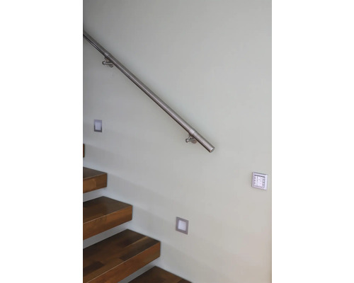 Treppe mit Holzstufen, Metallgeländer und Wandleuchten