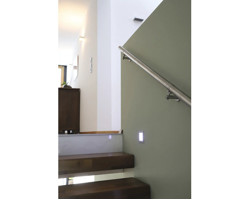 Treppenhaus mit Holzstufen, Edelstahlgeländer und Wandleuchte