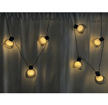 Guirlande lumineuse avec des lampes rondes devant un rideau