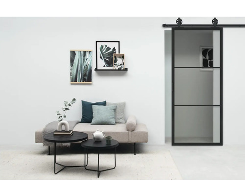 Salon avec canapé, tables basses, tableaux et porte coulissante