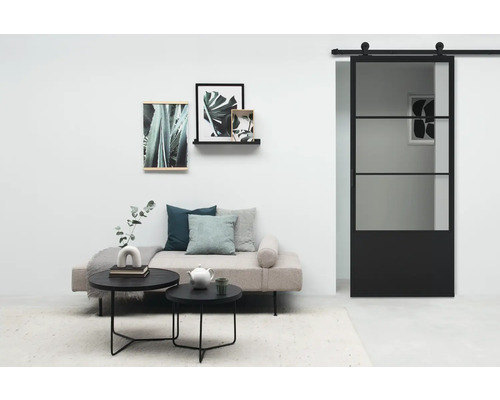 Salon avec porte coulissante, canapé, tables basses et décoration murale