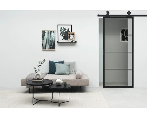 Salon avec porte coulissante, canapé, table basse et décoration murale