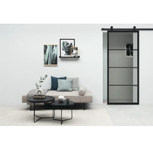 Salon avec porte coulissante, canapé, tables basses et décorations murales pour un intérieur moderne.