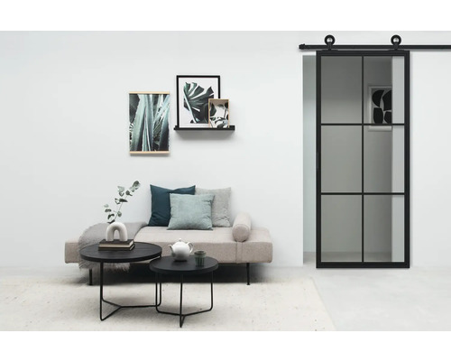 Salon avec porte coulissante, canapé, tables basses et décoration murale