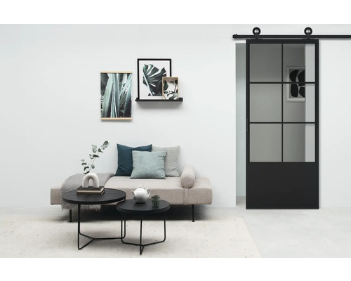 Salon avec porte coulissante, canapé, tables basses et décoration murale