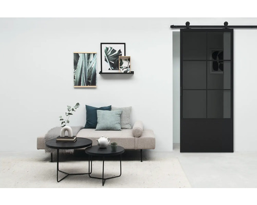 Salon avec canapé, tables basses, décoration murale et porte coulissante