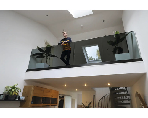 Helles Wohnzimmer mit Galerie, Glasgeländer und Zimmerpflanzen