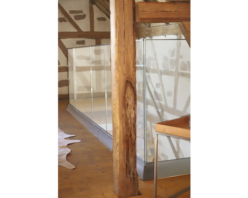 Vue intérieure d''une maison avec des poutres en bois et une balustrade en verre.