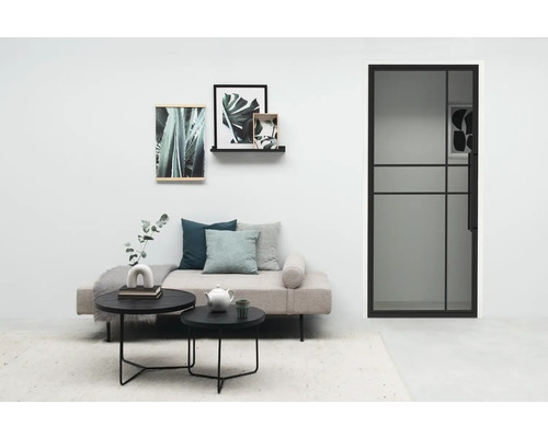 Salon lumineux avec porte, canapé, table basse et décoration